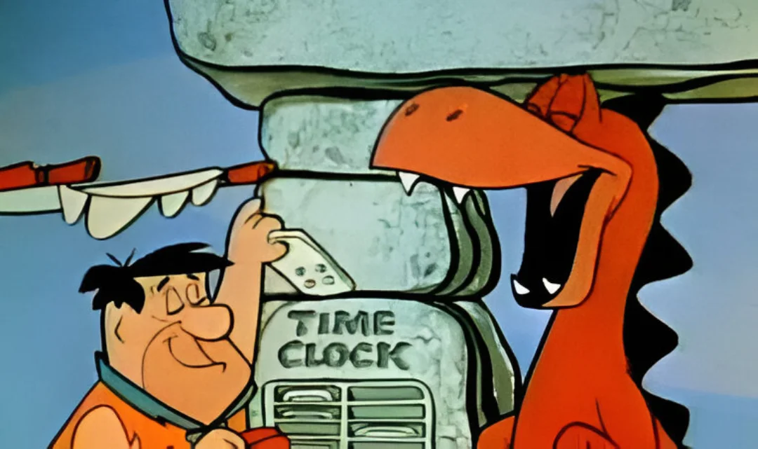 A scene from the Flinstones of Fred cloking into work with a stone time clock